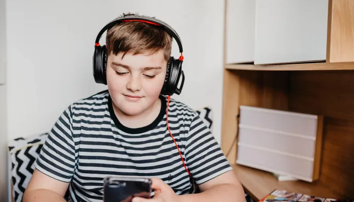 Teenage boy listening to music in his room.