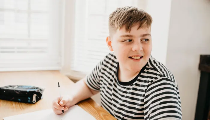 Teenage boy writing