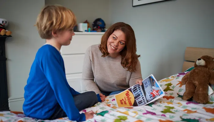 Woman showing child poster saying welcome to your new home