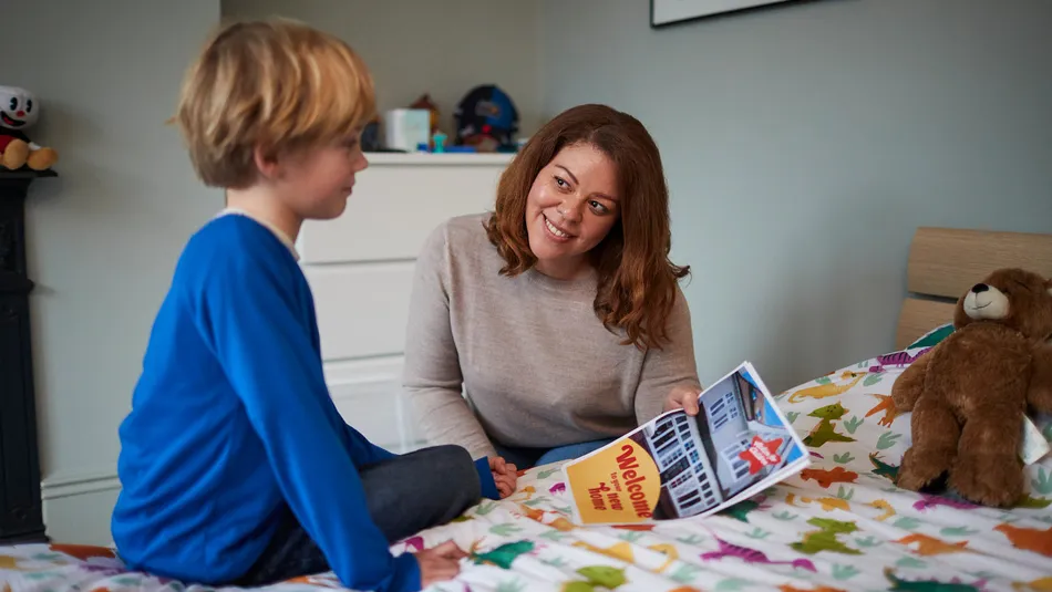 Woman showing child poster saying welcome to your new home