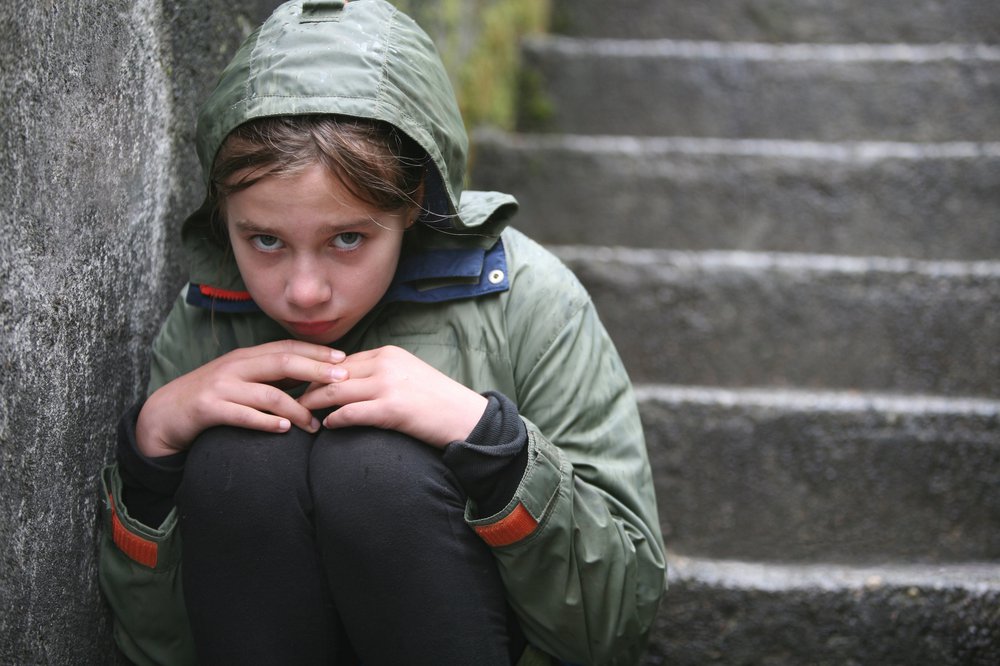 Worried young girl on stone staircase