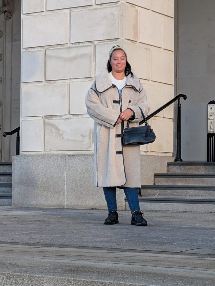 Young Ambassador, Leah, standing on some steps and smiling at the camera