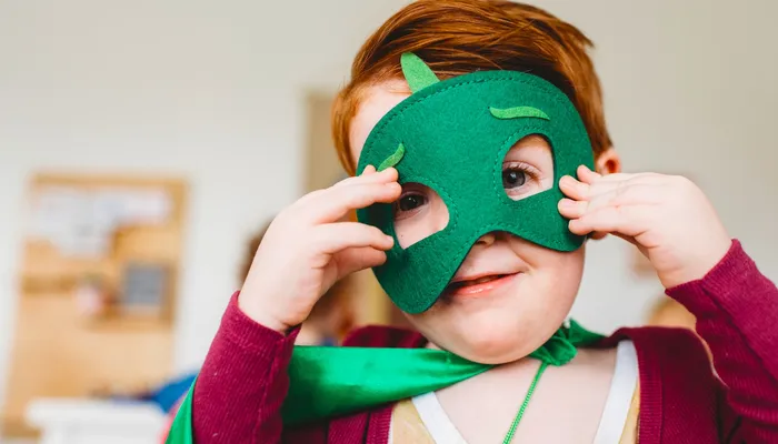 Young boy wearing superhero costume