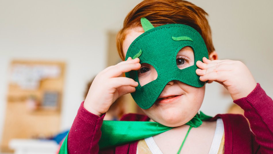 Young boy wearing superhero costume