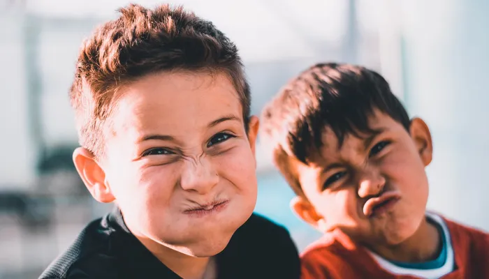 Two young boys making silly faces.