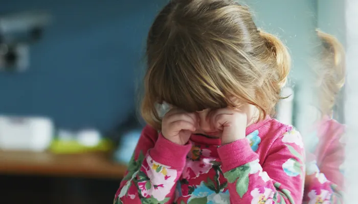 Young girl rubbing eyes