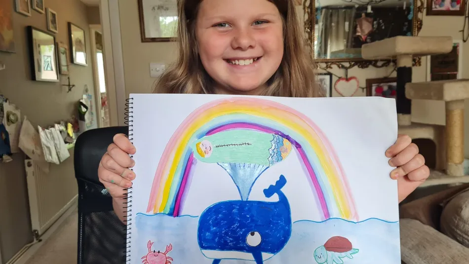 Eliza shows off her Action for Children Drawing Challenge entry
