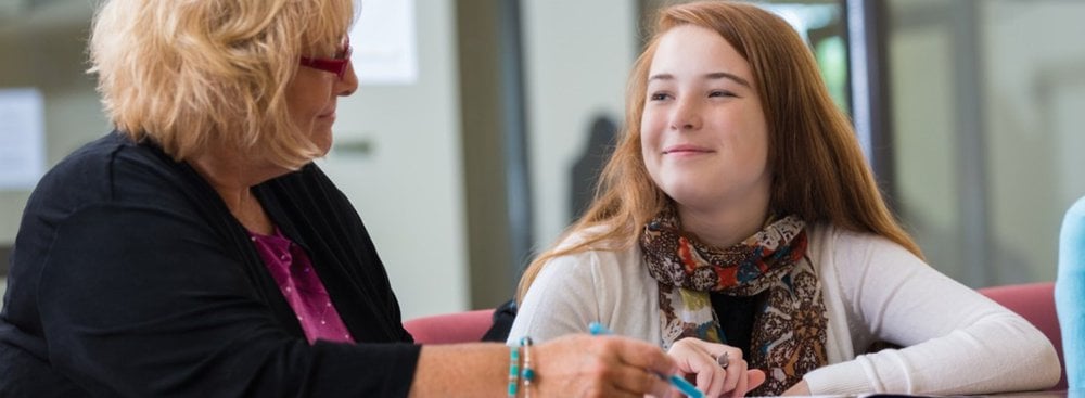 Young teenage girl and older lady sat having a conversation