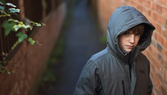boy in alley looking worried