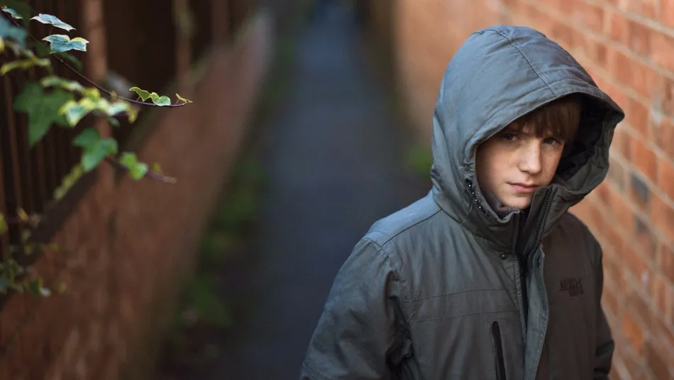 boy in alley looking worried