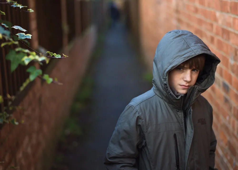 boy in alley looking worried