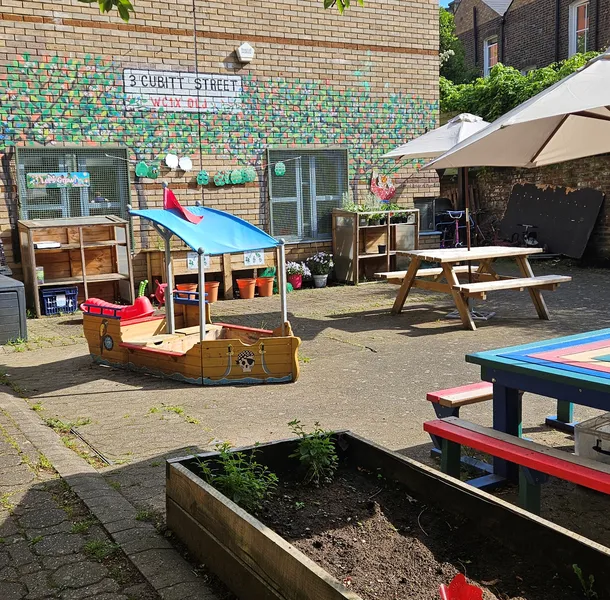 The front garden of Cubitt Street with picnic tables, sandpit and planter