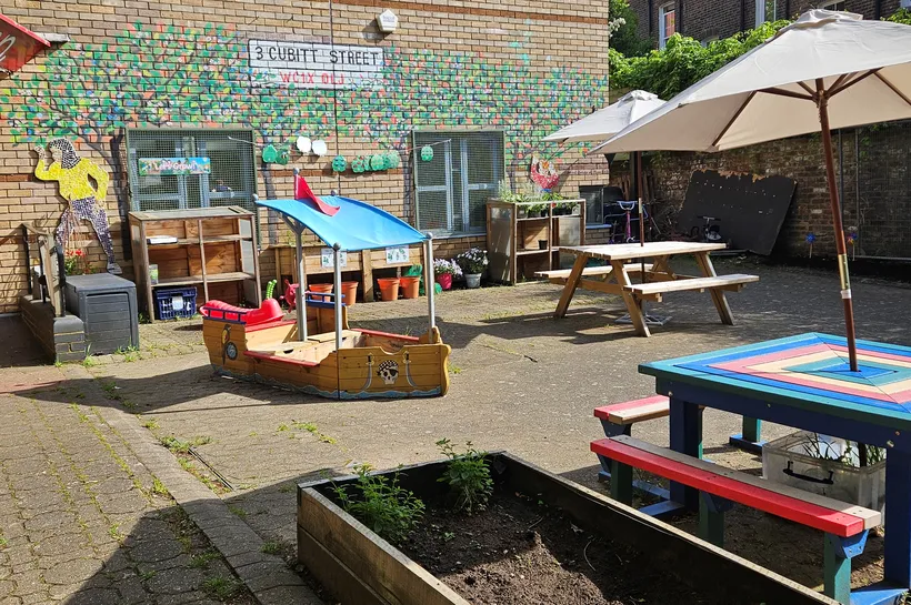 The front garden of Cubitt Street with picnic tables, sandpit and planter