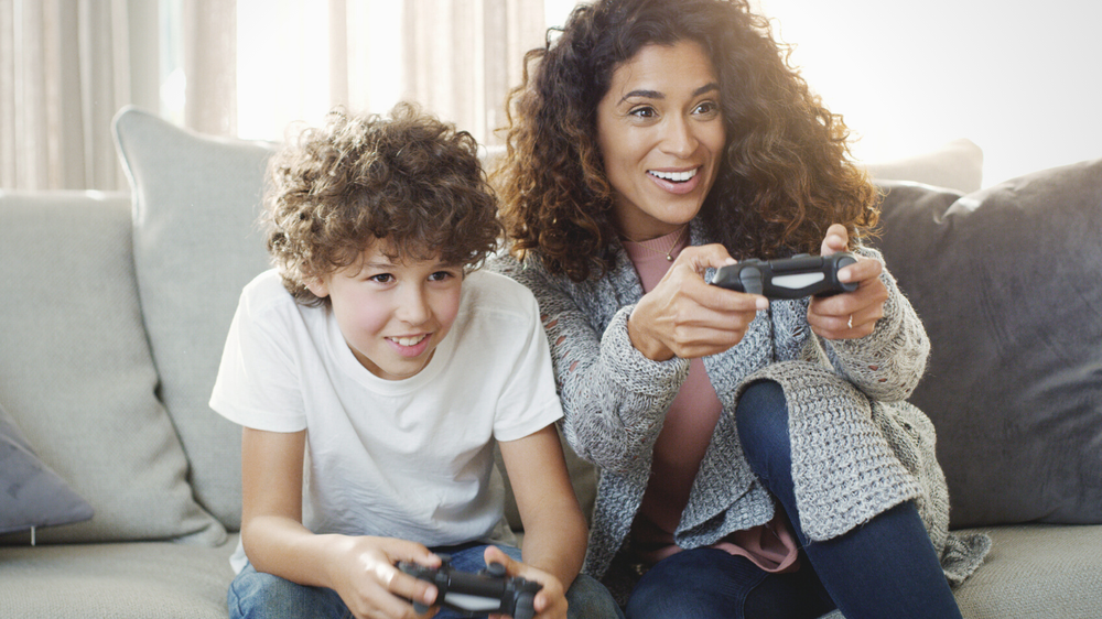 Shot of a young mother and her son playing video games together at home