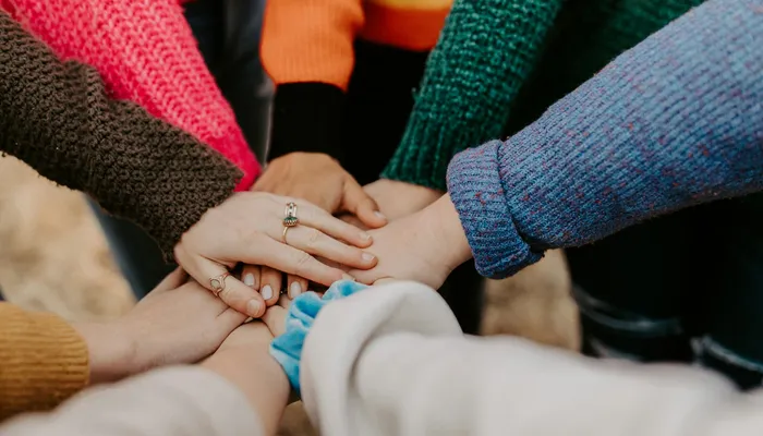 girl friends hands piled togethger