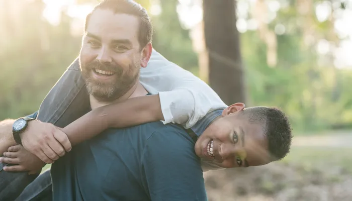 Happy son and father playing in woods