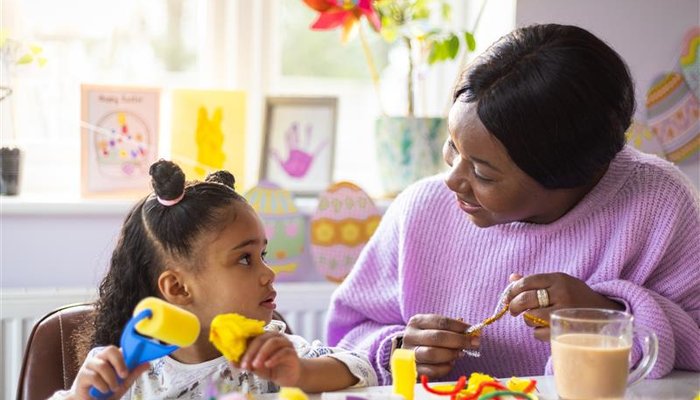 Female carer doing arts and crafts with a foster child, showing creativity and purposeful support