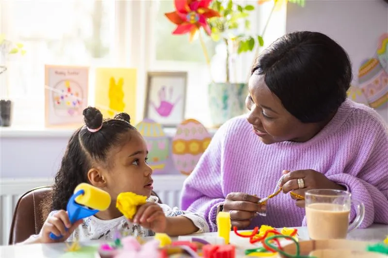 Female carer doing arts and crafts with a foster child, showing creativity and purposeful support