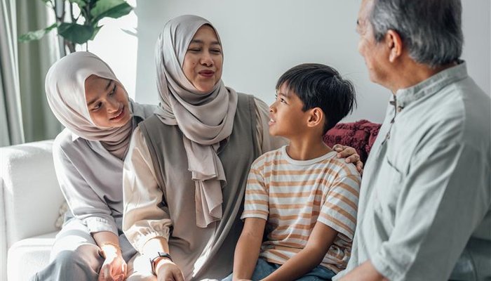 Foster parents and their daughter sharing a moment with a foster child, challenging myths about who can foster
