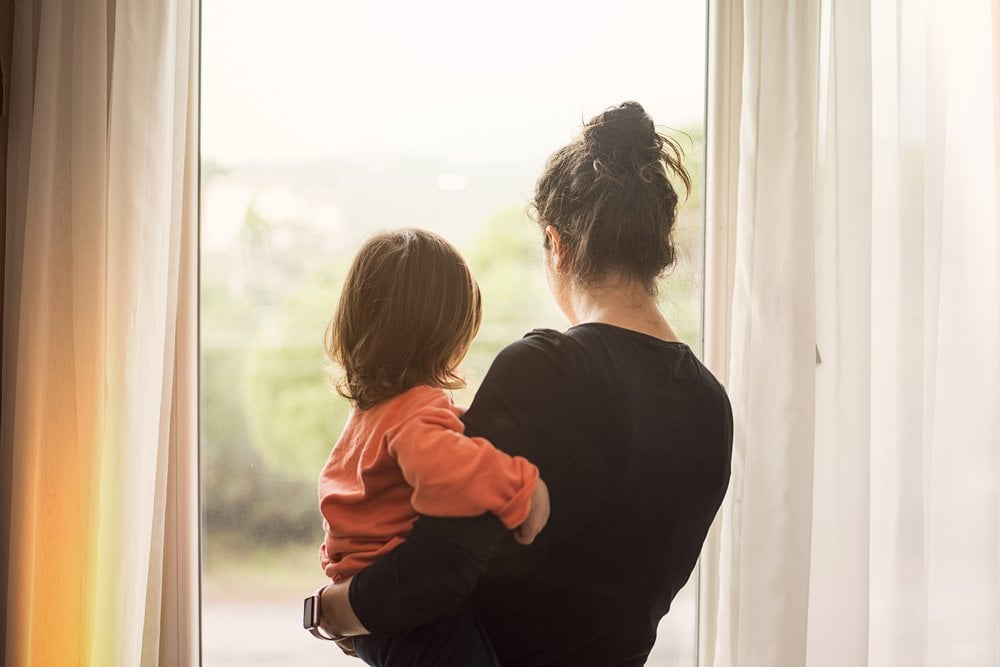 mother holding child looking out of window.jpg