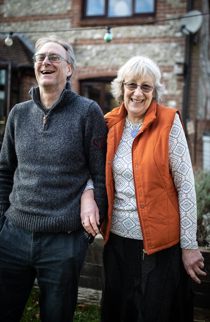 Heather and Kelvin standing in their garden laughing