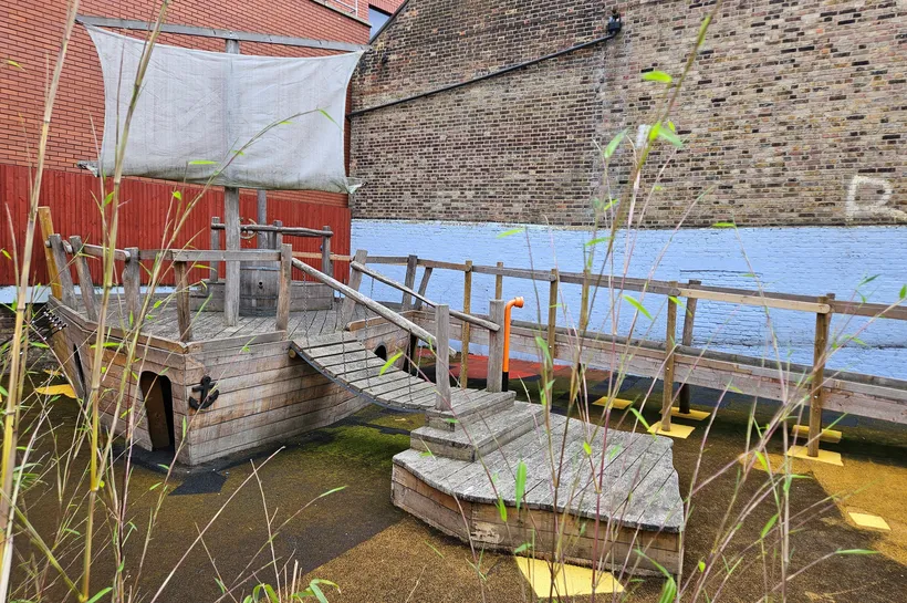 A wooden pirate ship complete with sail and wobbly bridge