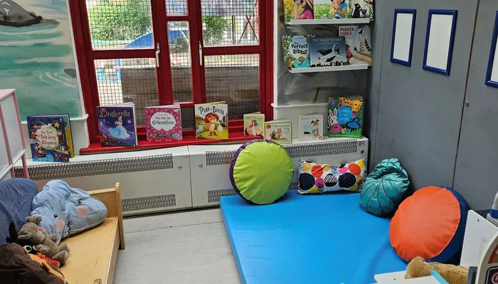 The reading area of a playroom with a comfy matt and cushions