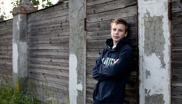 Boy standing outside in tracksuit looking into camera